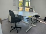 a white table with two black chairs in a room