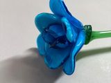 two blue flowers that are sitting on a table