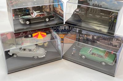 quatre modèles réduits de voitures dans une vitrine posée sur une table