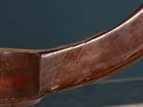 a close up of a wooden chair with a leather seat