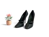 pair of black high heeled shoes sitting next to a potted plant