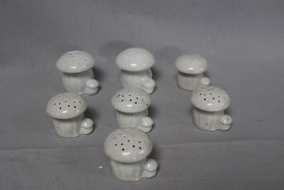 a lot of small white ceramic mushrooms on the table
