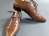 men ' s brown leather shoes with laces on a gray surface
