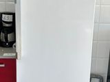 a white refrigerator in a kitchen with a red cabinet