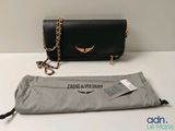 Le sac est noir et porte un logo doré.