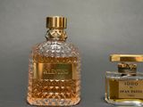 two bottles of perfume sitting next to each other on a table