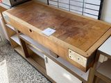 une table en bois avec des tiroirs, dans une pièce