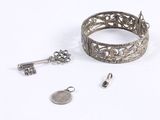 a silver bracelet and a silver ring with a key on it