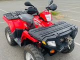 a red four wheeler atv parked in a parking lot next to a parking lot
