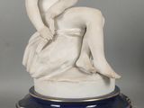 paire de figurines en porcelaine représentant une femme assise sur un socle en marbre