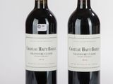 deux bouteilles de vin rouge posées l'une à côté de l'autre sur une surface blanche