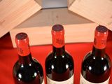 three bottles of wine sitting on a red table