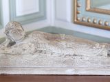 une statue représentant un oiseau perché sur une table devant un miroir