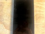 a broken cell phone sitting on a wooden table