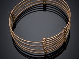 a close up of a gold bracelet on a black surface