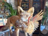 statue of a fox with a bird in its mouth on a table