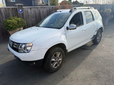 une photo d'une Dacia blanche garée sur un parking
