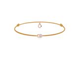un bracelet en or orné d'un diamant blanc et d'une pierre verte