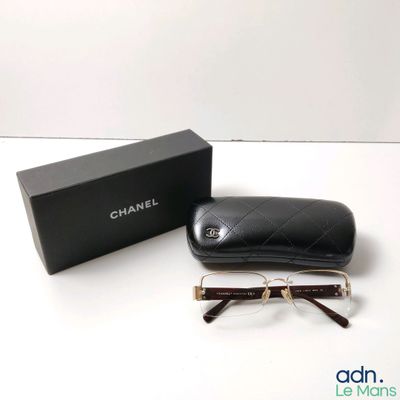 une paire de lunettes posée sur une table à côté d'une boîte