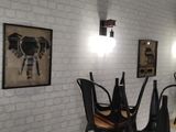 a room with a table, chairs, and pictures on the wall