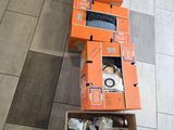 Plusieurs cartons contenant des objets divers sont posés par terre dans une pièce.