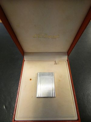 an image of a silver lighter in a red box on a table