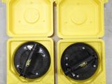 deux boîtes en plastique jaunes avec des couvercles noirs posées sur une surface blanche