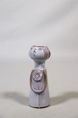 une petite figurine en céramique représentant une femme avec un chat sur l'épaule