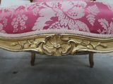 a pink and gold chair with a pink cushion on it