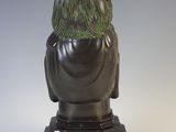 statue of a woman sitting on a pedestal with her back to the camera