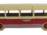 un petit bus en plastique posé sur une surface blanche