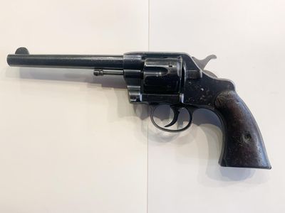 revolver on a white surface with a black handle