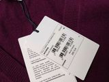 the label on a purple sweater is attached to a tag