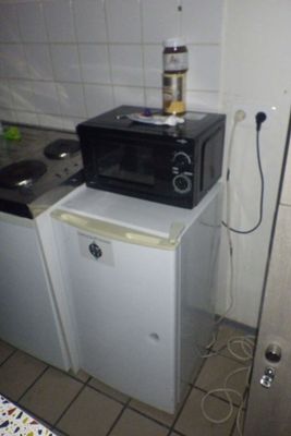 un micro-ondes posé sur un petit réfrigérateur dans une cuisine