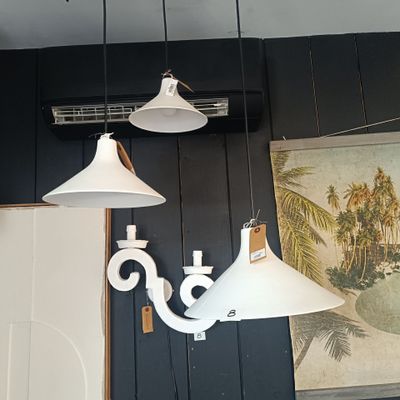 trois lampes blanches suspendues au plafond dans une pièce