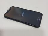 the back of a black phone sitting on top of a white table