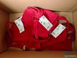 a box with a red bag and two tags on it
