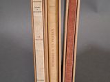 trois livres sont empilés sur une surface grise