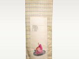 an oriental scroll hanging on a wall with a painting of a woman in a lotus position