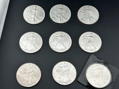 quelques pièces d'argent sont posées sur une surface noire, à côté d'une feuille de papier