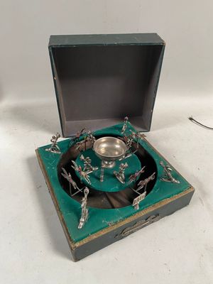une assiette en argent dans une boîte posée sur une surface blanche