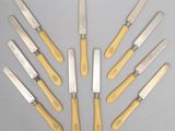 six couteaux à manche jaune sont disposés en cercle sur une surface grise