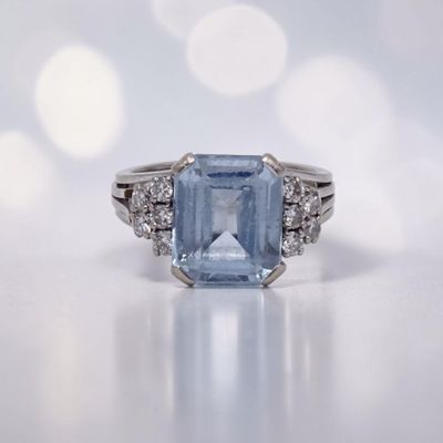 gros plan d'une bague avec une topaze bleue entourée de diamants