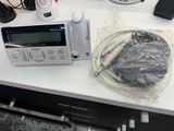 a microwave sitting on a counter with a bunch of electronics on it