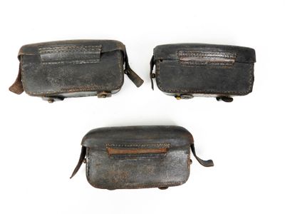 trois morceaux de vieux cuir sont présentés sur une surface blanche