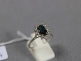 gros plan d'une bague avec une pierre noire entourée de diamants blancs