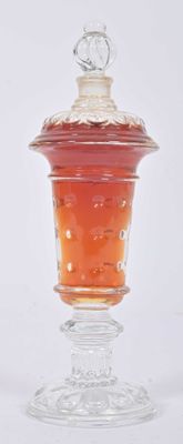 a glass jar with a lid on a glass stand