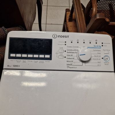 a white washing machine sitting on a tiled floor
