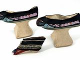 three pairs of shoes that are sitting on a wooden stand