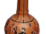 un vase marron orné d'un motif sur fond blanc